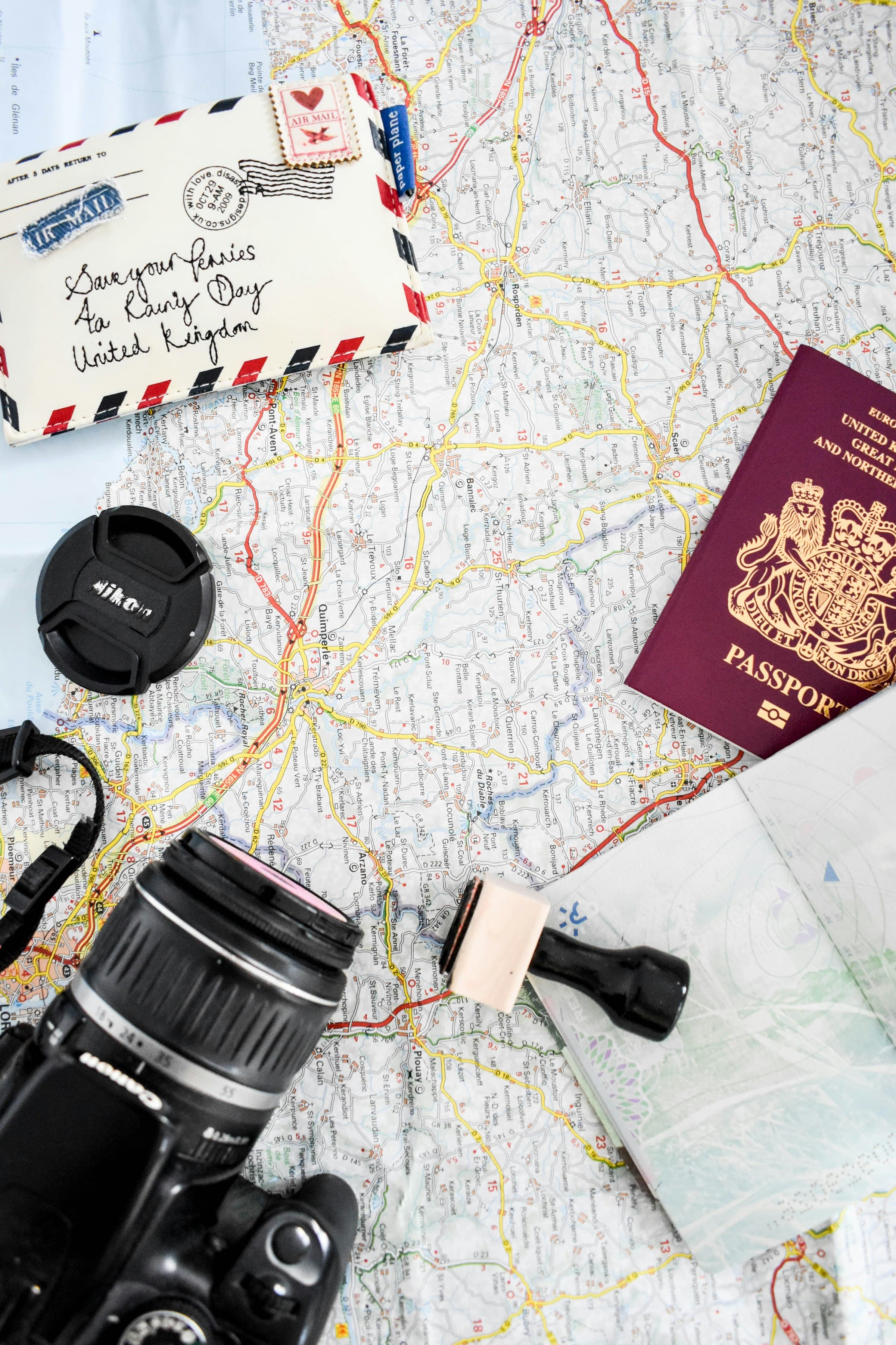 Une carte routière, un appareil photo et un passeport posés sur une table
